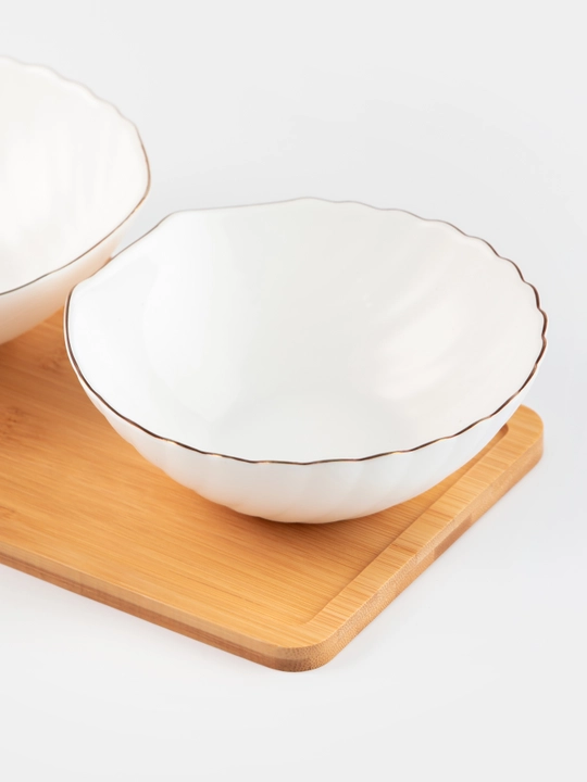 Yog‘och taglik ustidagi salat idishlari va dasturxon idishlari to‘plami