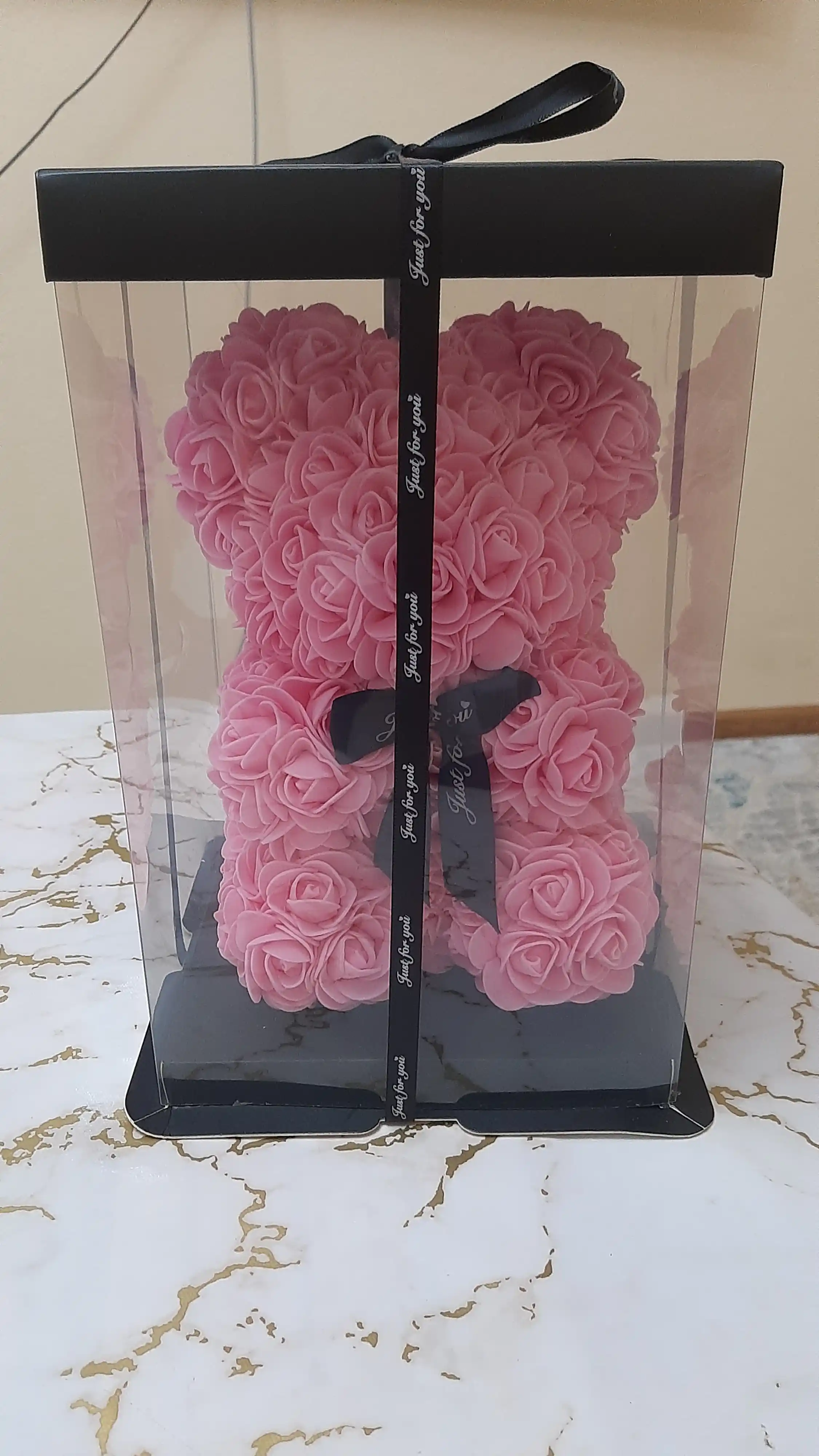 Yangi yil sovg'asi sifatida yonib turgan ayiqcha, qutidagi atirgullardan yasalgan suvenir