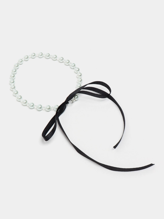 Choker ayollar uchun lenta va marvariddan va kamon bilan qora toshlardan, bo'yin bezagi