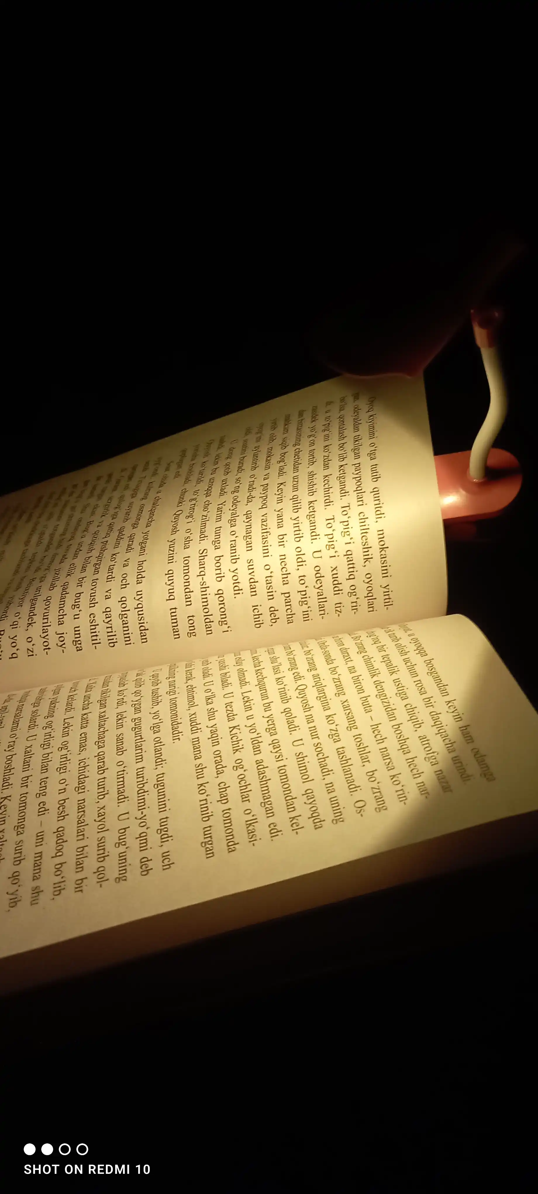 Kitob o‘qish uchun yorug‘lik diodli lampa, stol ustida, qisqichda
