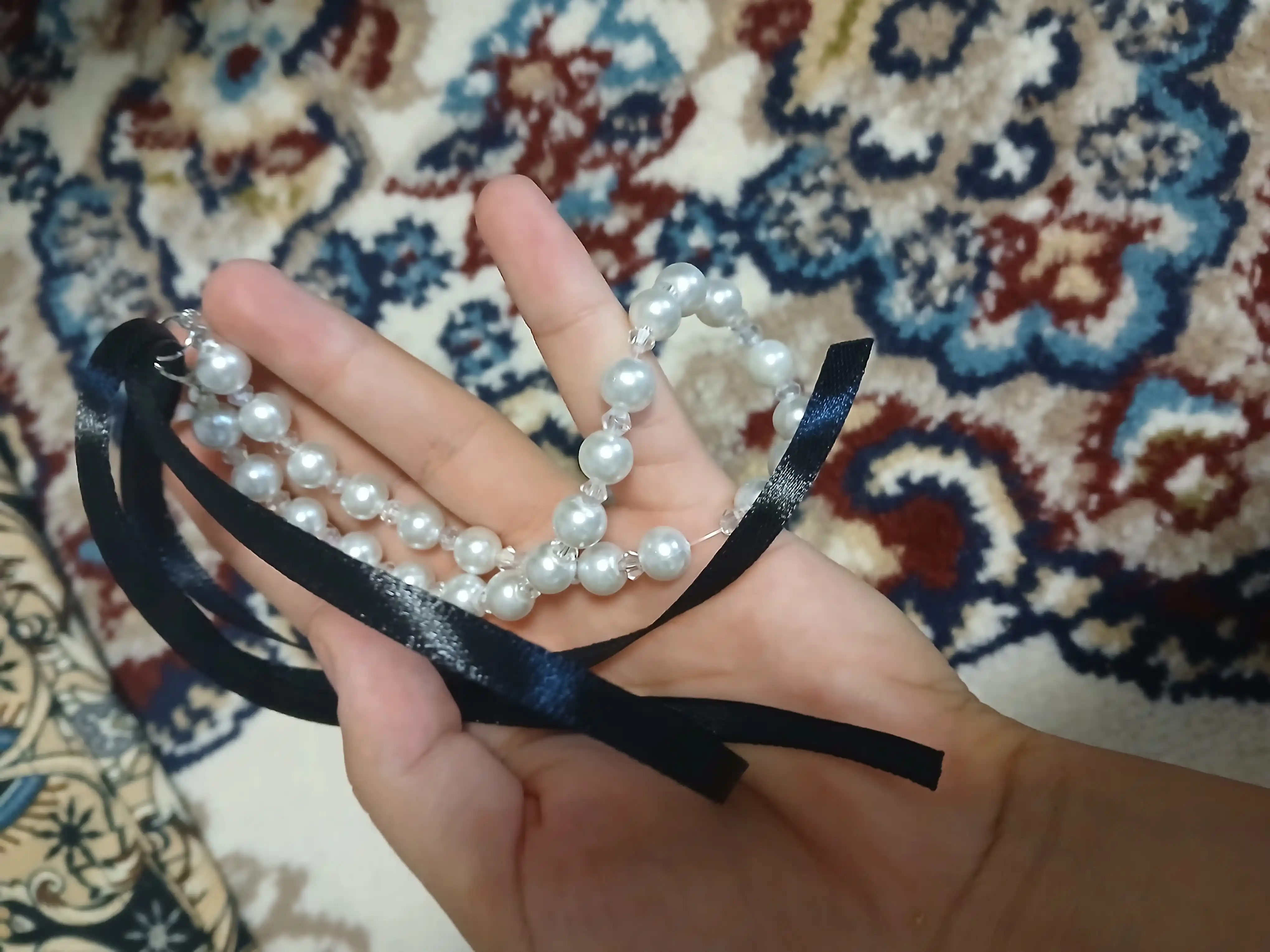 Choker ayollar uchun lenta va marvariddan va kamon bilan qora toshlardan, bo'yin bezagi
