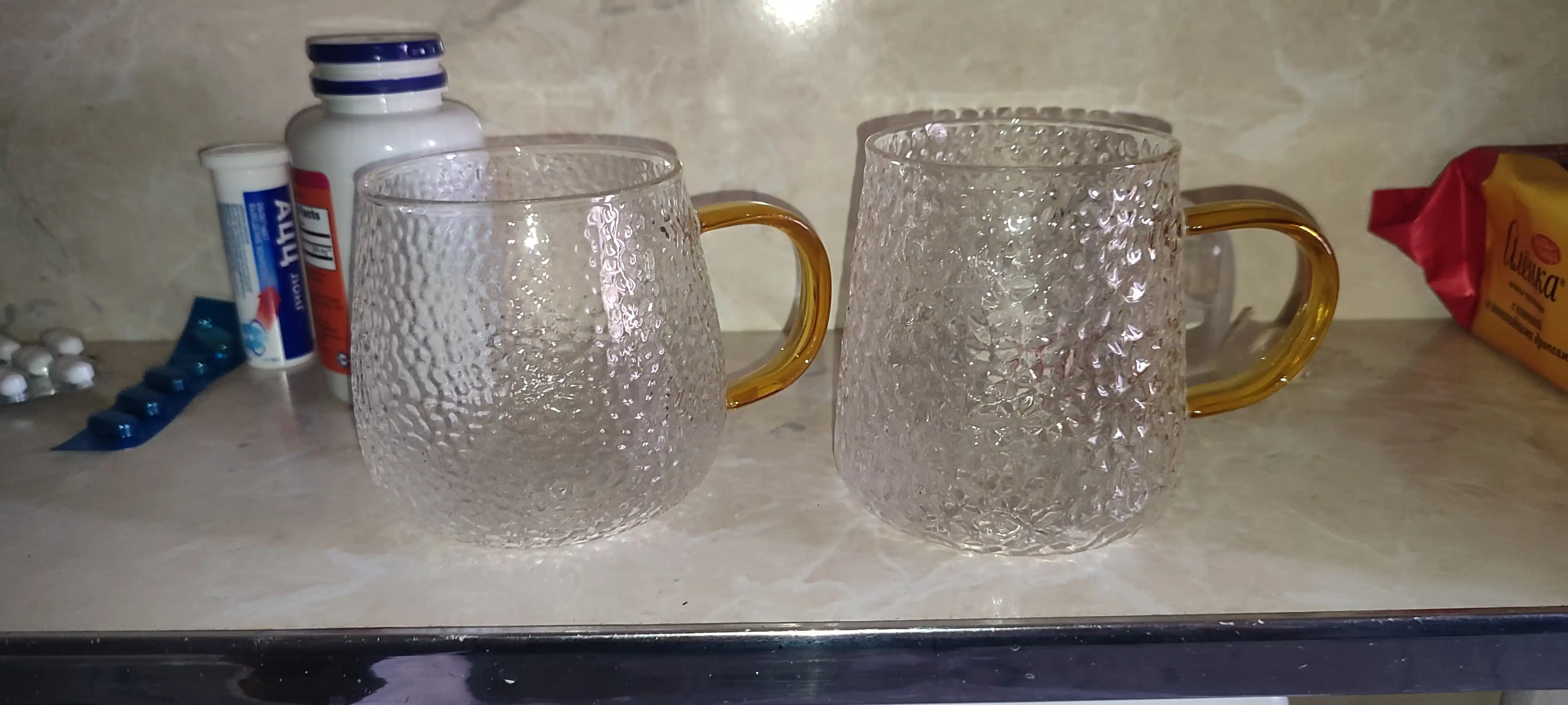 To'qimalangan sirt va oltin tutqichli shisha krujka
