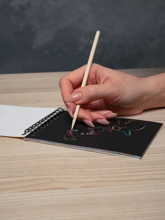 Qora sketchbuk, oq va tilla ruchkasi bilan birga, sketchbuk