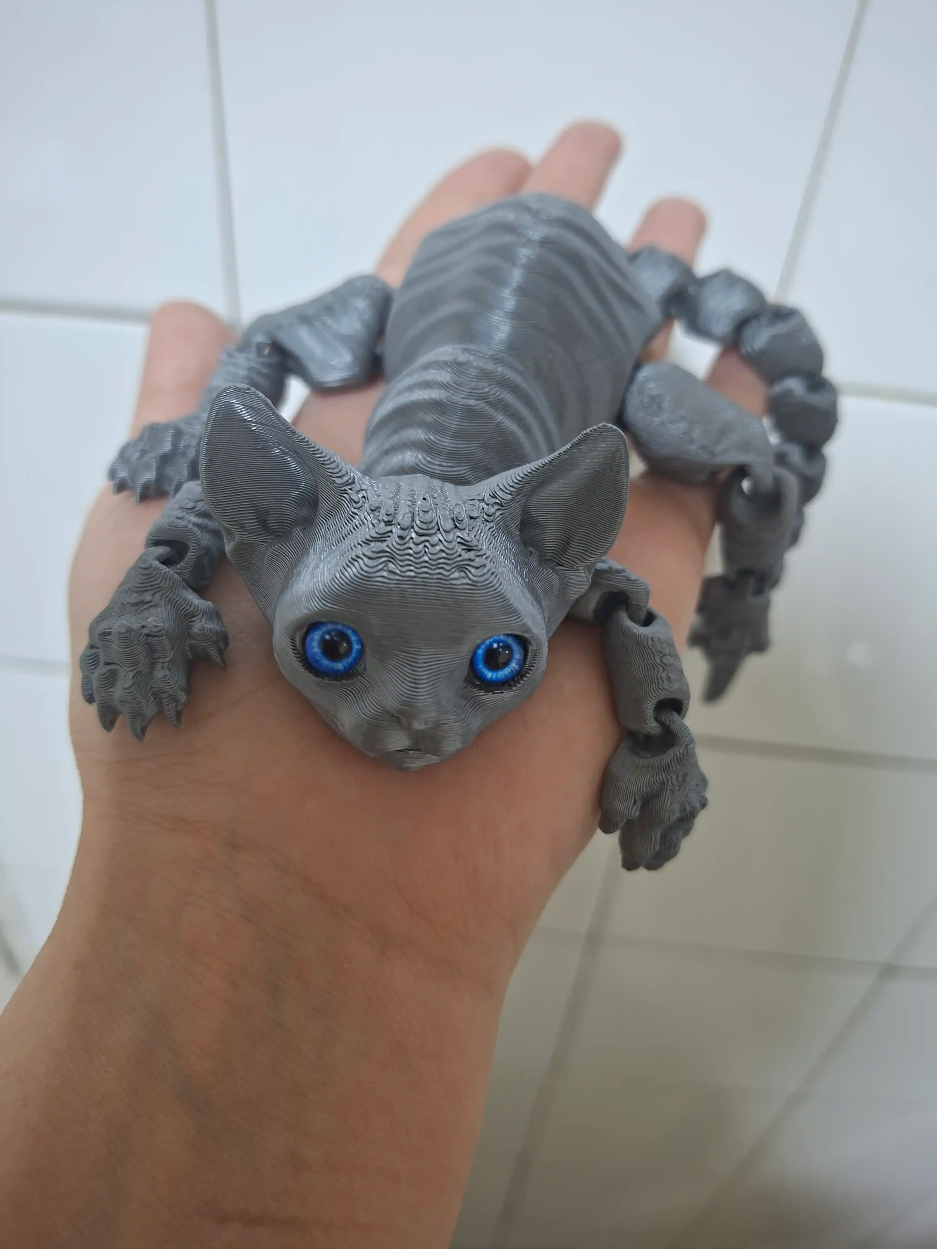 3D printerda chop etilgan antistress harakatlanuvchi o‘yinchoq mushukcha sfinks
