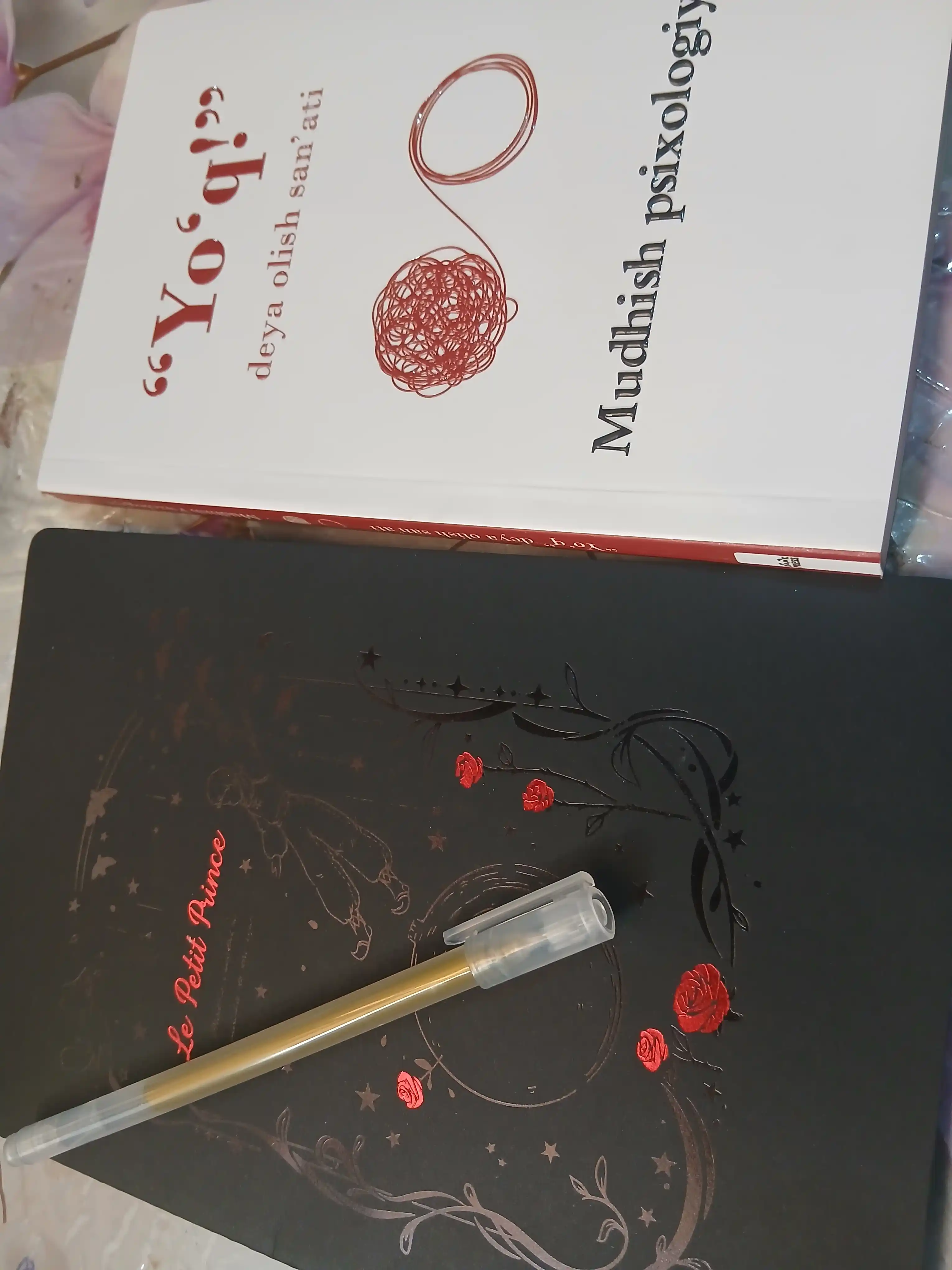 Qora sketchbuk, oq va tilla ruchkasi bilan birga, sketchbuk