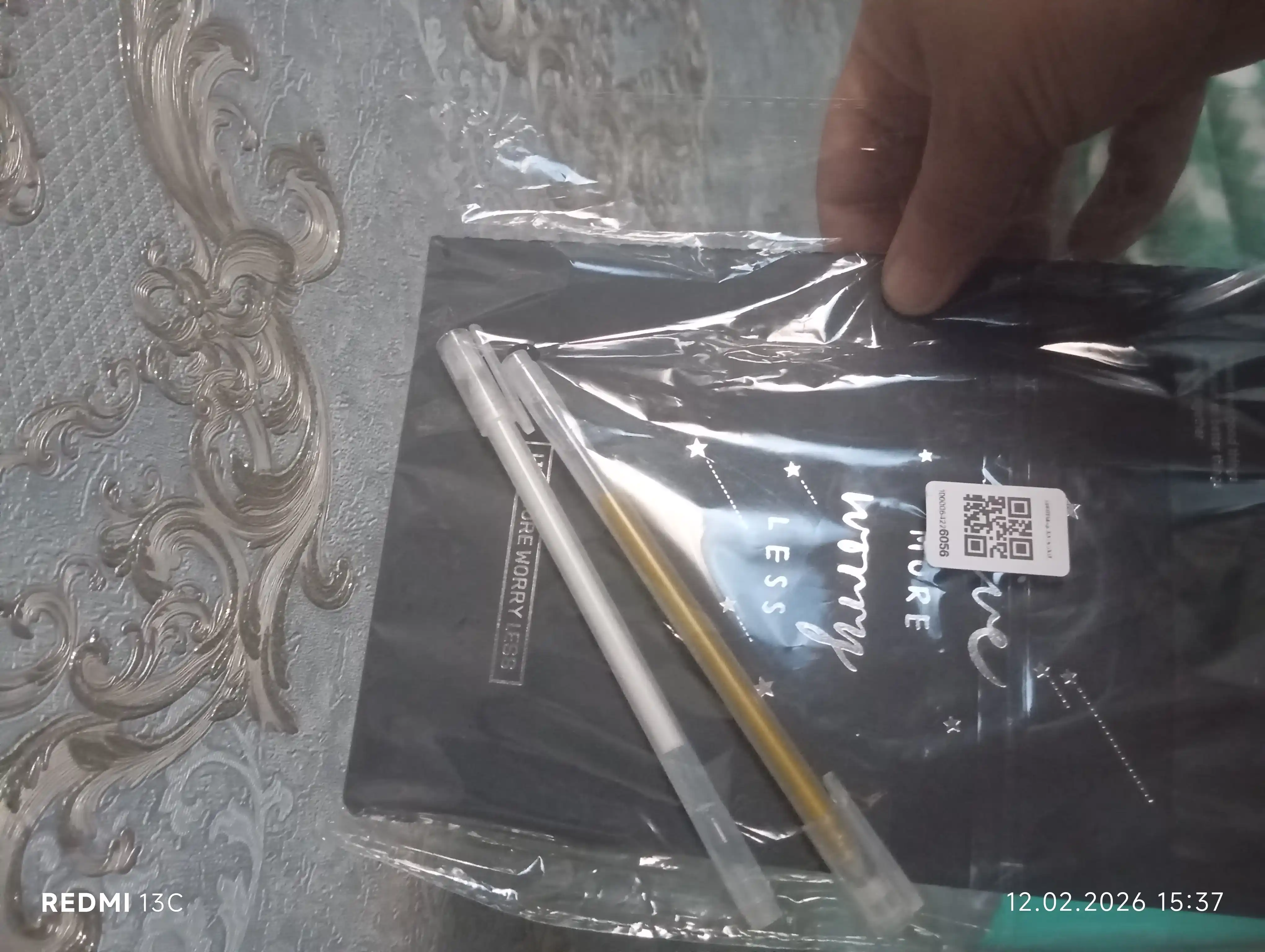 Qora sketchbuk, oq va tilla ruchkasi bilan birga, sketchbuk
