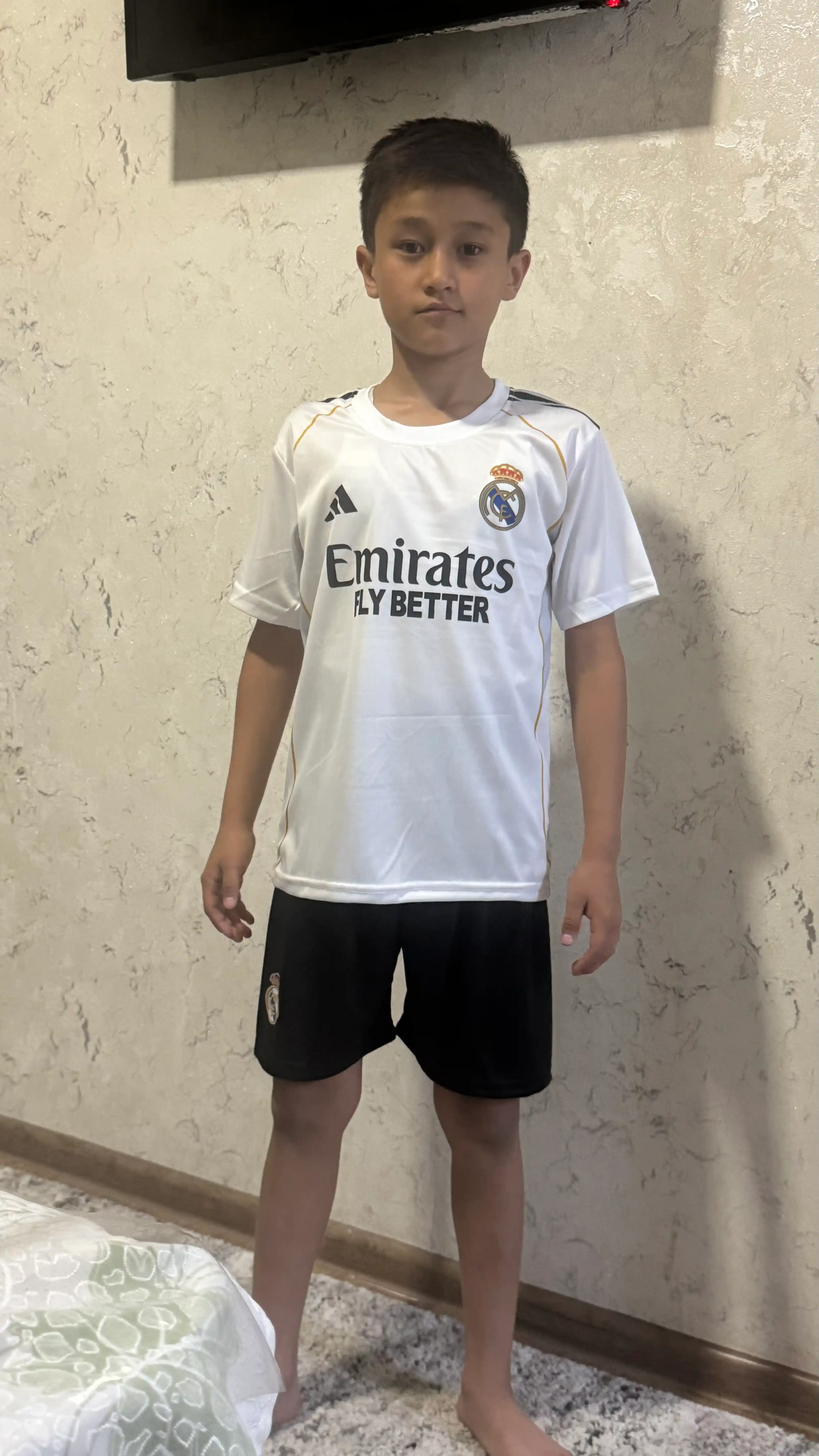 Mbappe, Lamin Yamal, Ronaldo va Husanov tasvirlangan bolalar futbolkalari