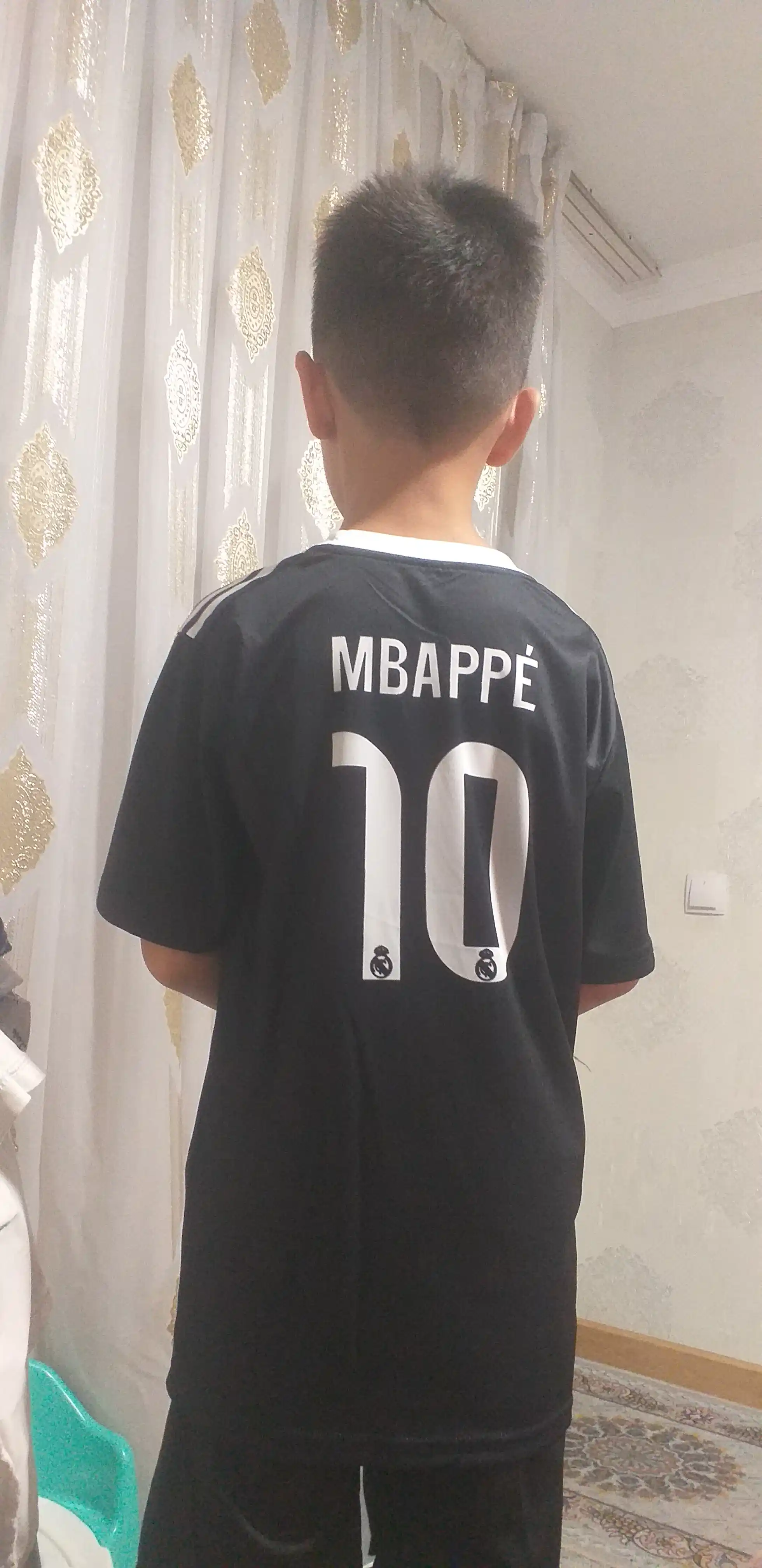 Mbappe, Lamin Yamal, Ronaldo va Husanov tasvirlangan bolalar futbolkalari