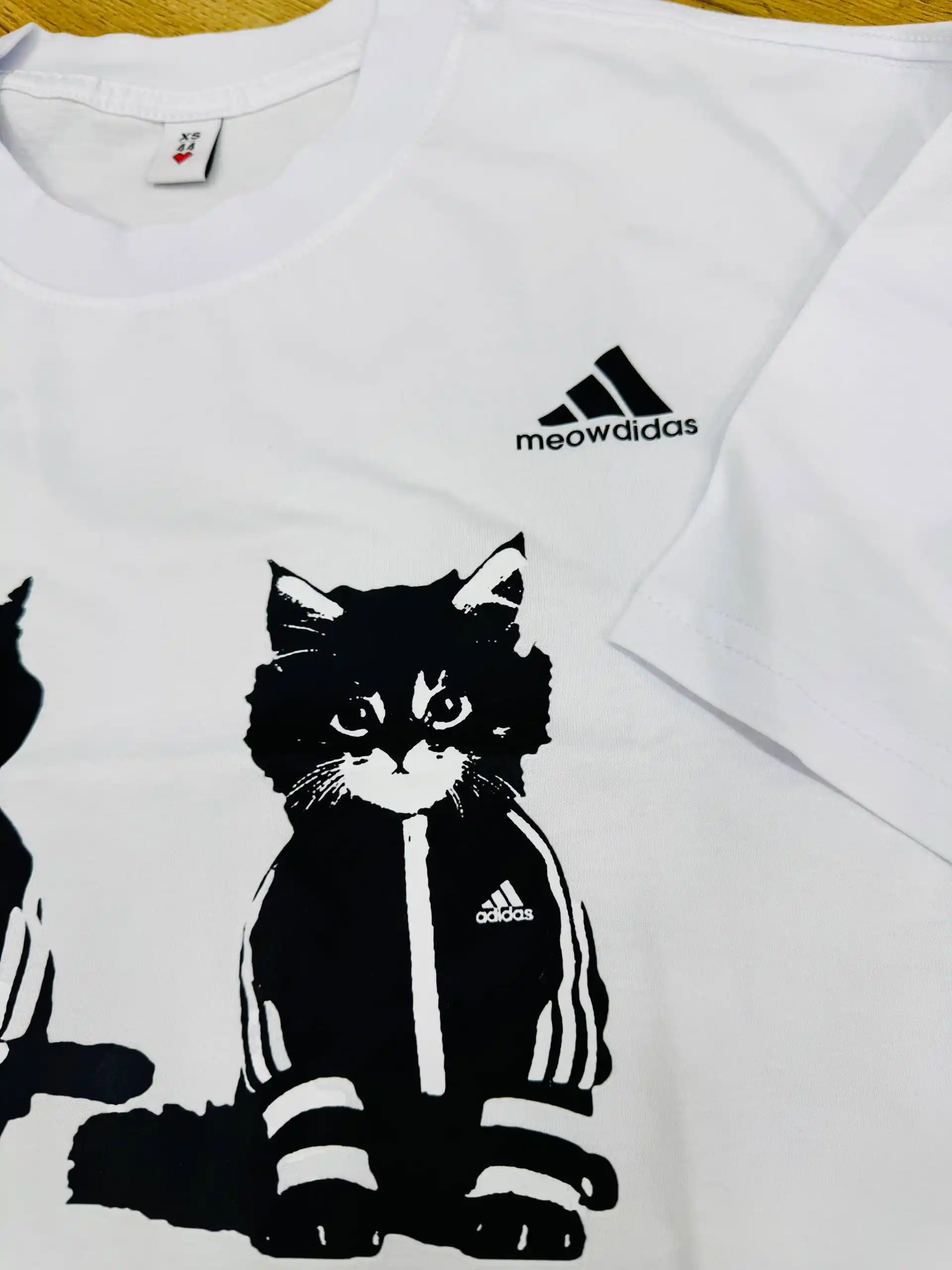 "Meowdidas" Y2K uslubidagi mushuk tasviri tushirilgan futbolka