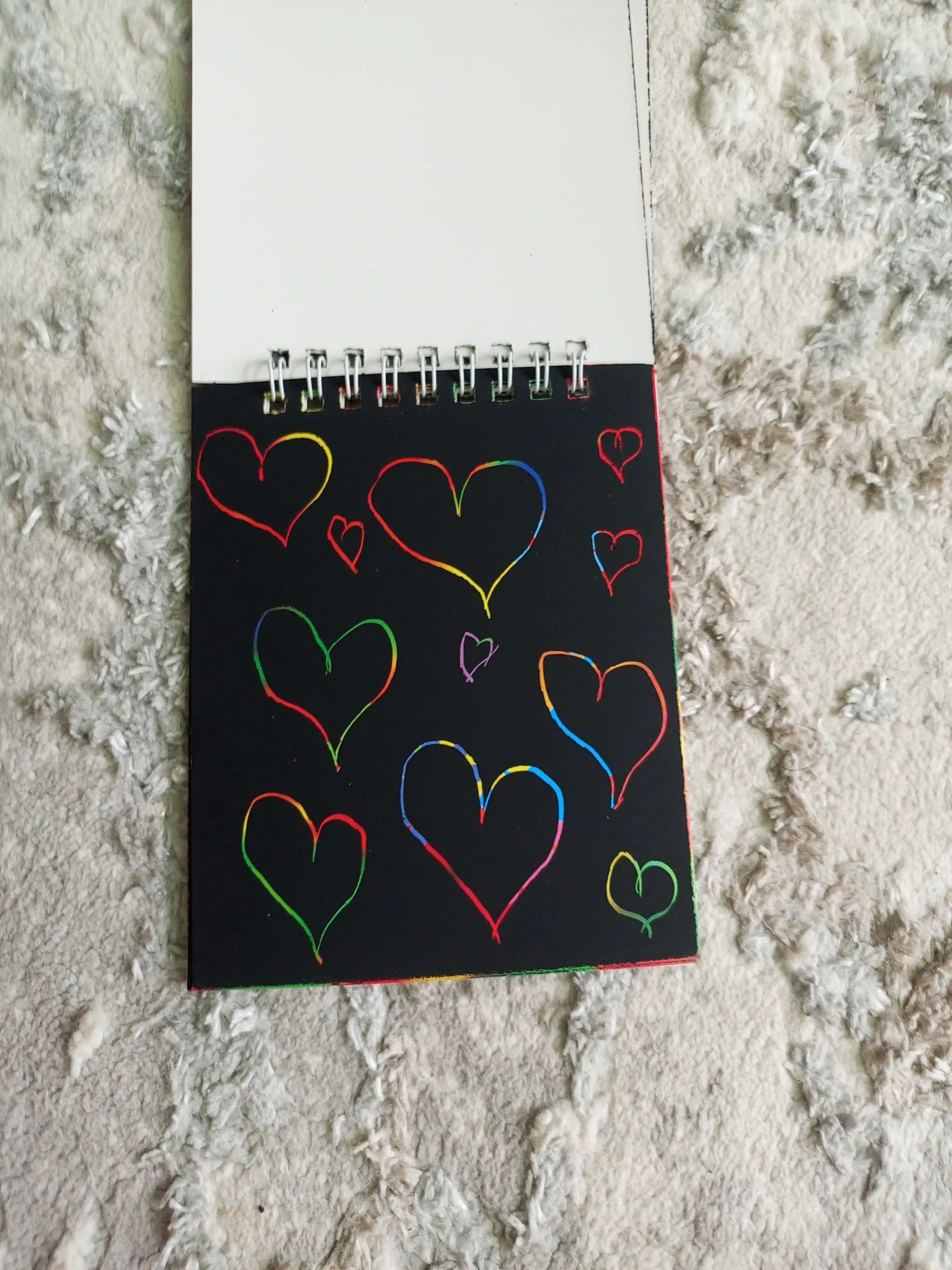 Qora sketchbuk, oq va tilla ruchkasi bilan birga, sketchbuk
