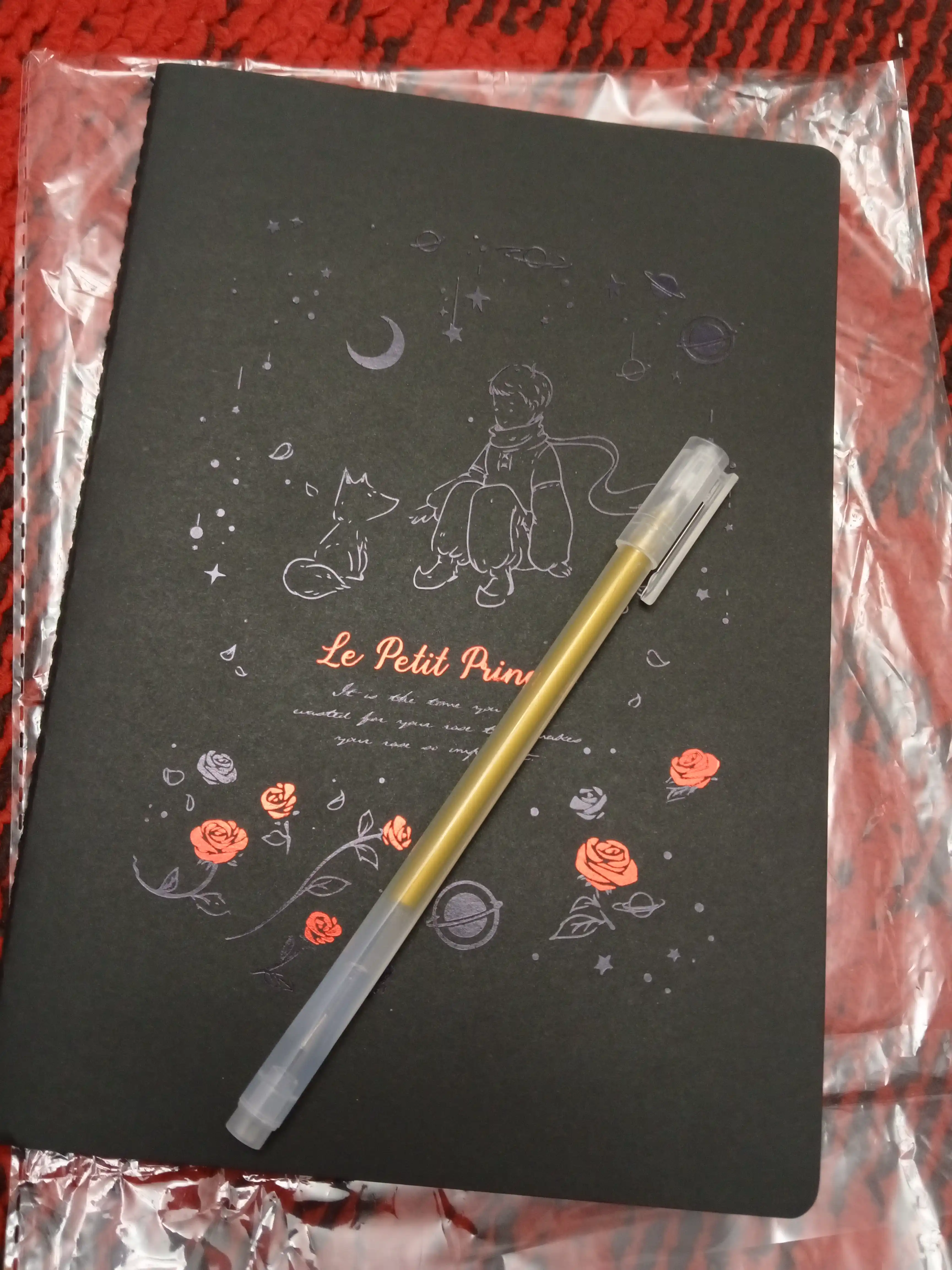 Qora sketchbuk, oq va tilla ruchkasi bilan birga, sketchbuk